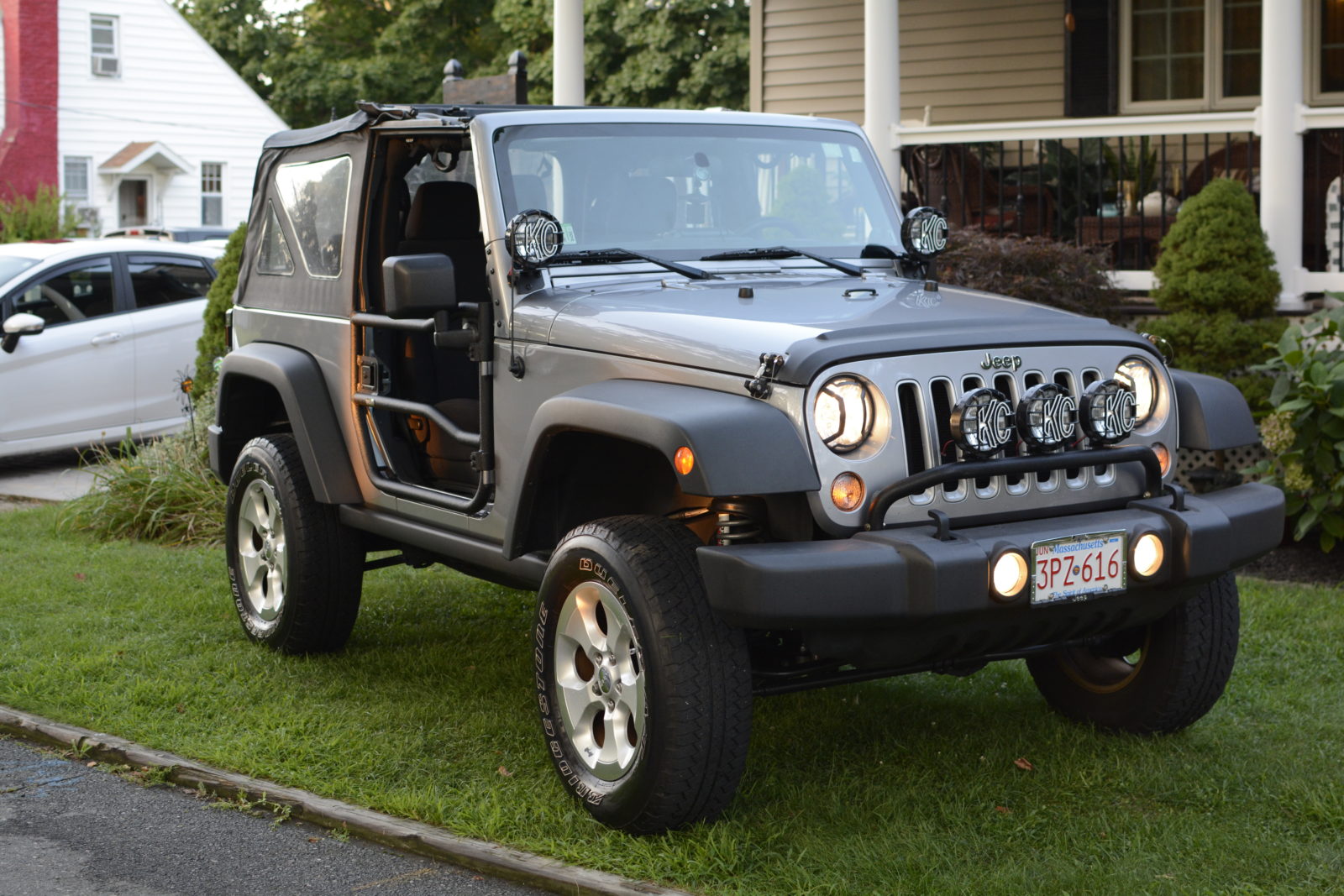 Gray Jeep Wrangler with removed doors parked